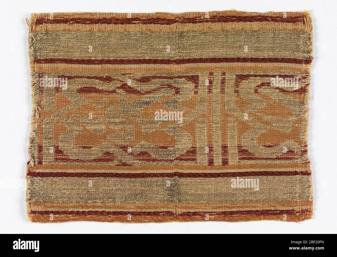Frammento. Fascia ornamentale con disegno di reggetta intrecciata contenente un'immagine indistinta di uccello con ali spalmare. Foto Stock Frammento. Fascia ornamentale con disegno di reggetta intrecciata contenente un'immagine indistinta di uccello con ali spalmare. Foto Stock