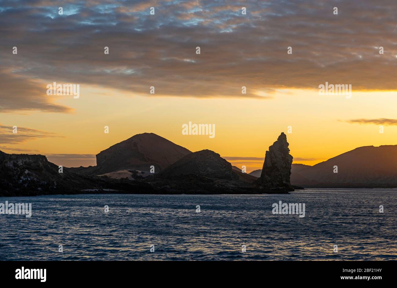 Silhouette della formazione di roccia di Pinnacle sull'isola di Bartolome al tramonto, parco nazionale di Galapagos, Ecuador. Foto Stock