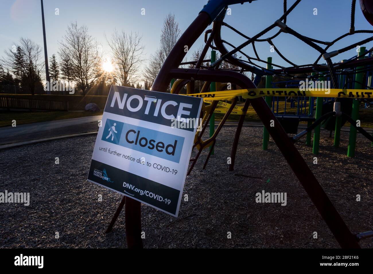 NORTH VANCOUVER, BC, CANADA - Apr 07, 2020: Un parco giochi chiuso in un parco pubblico North Vancouver fiancheggiato da nastro di attenzione per aiutare a limitare il Foto Stock