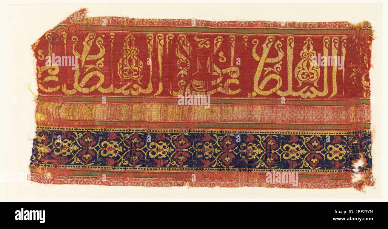 Frammento. Satinato a righe verticali in rosso rosa, rosso arancio, blu scuro, verde e bianco. Una larga striscia rossa rosata a sinistra ha un'iscrizione araba su larga scala in giallo (il tessuto deve essere girato di 90 gradi per leggere l'iscrizione islamica). Foto Stock