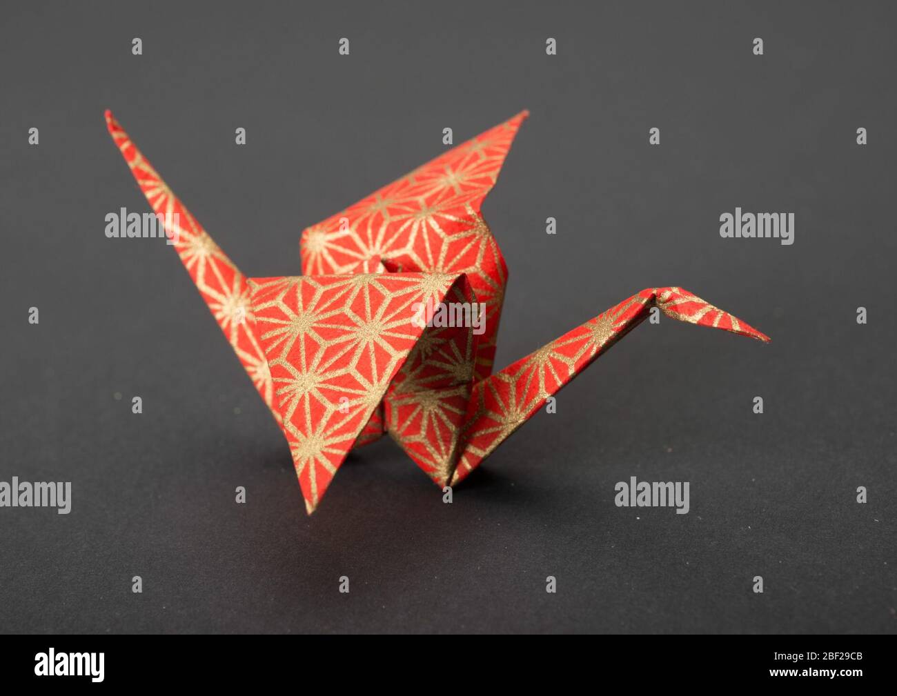 Origami Crane con disegni rossi e dorati. Foto Stock