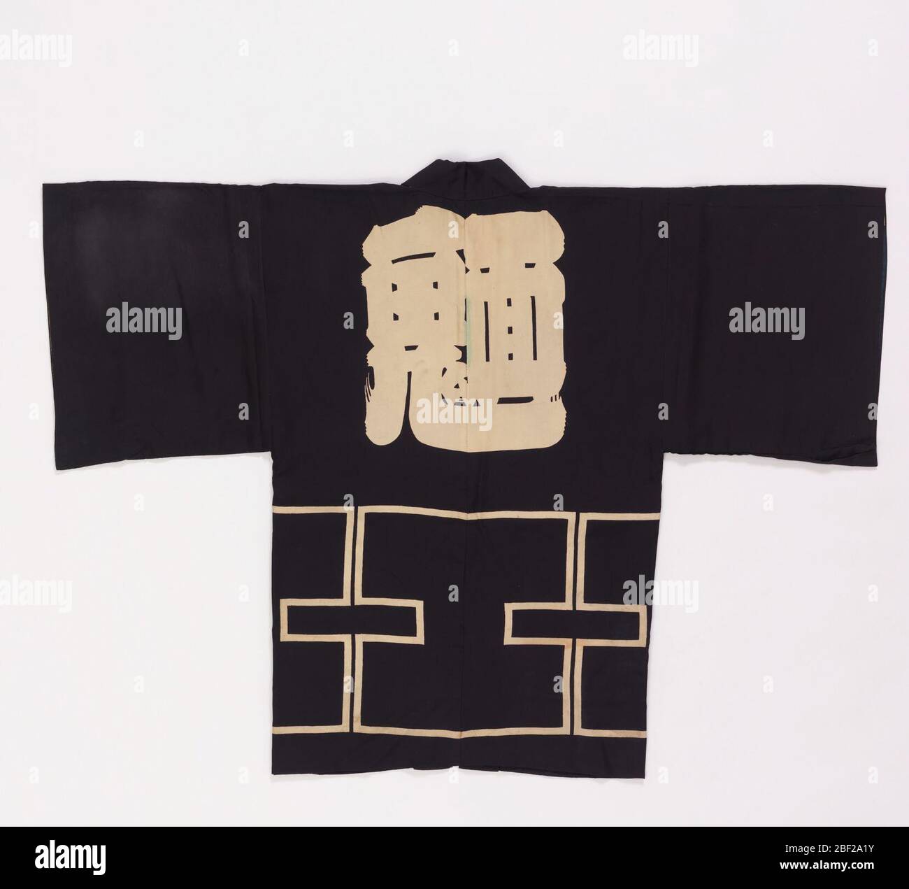 Cappotto corto. Cappotto corto di seta con grande carattere (probabilmente un segno di gilda) sul dorso centrale, con bordo a fret semplificato molto profondo sotto; due piccoli segni, uno sopra l'altro, su ogni lapello. Tutto riservato in bianco su un terreno blu profondo. Foto Stock