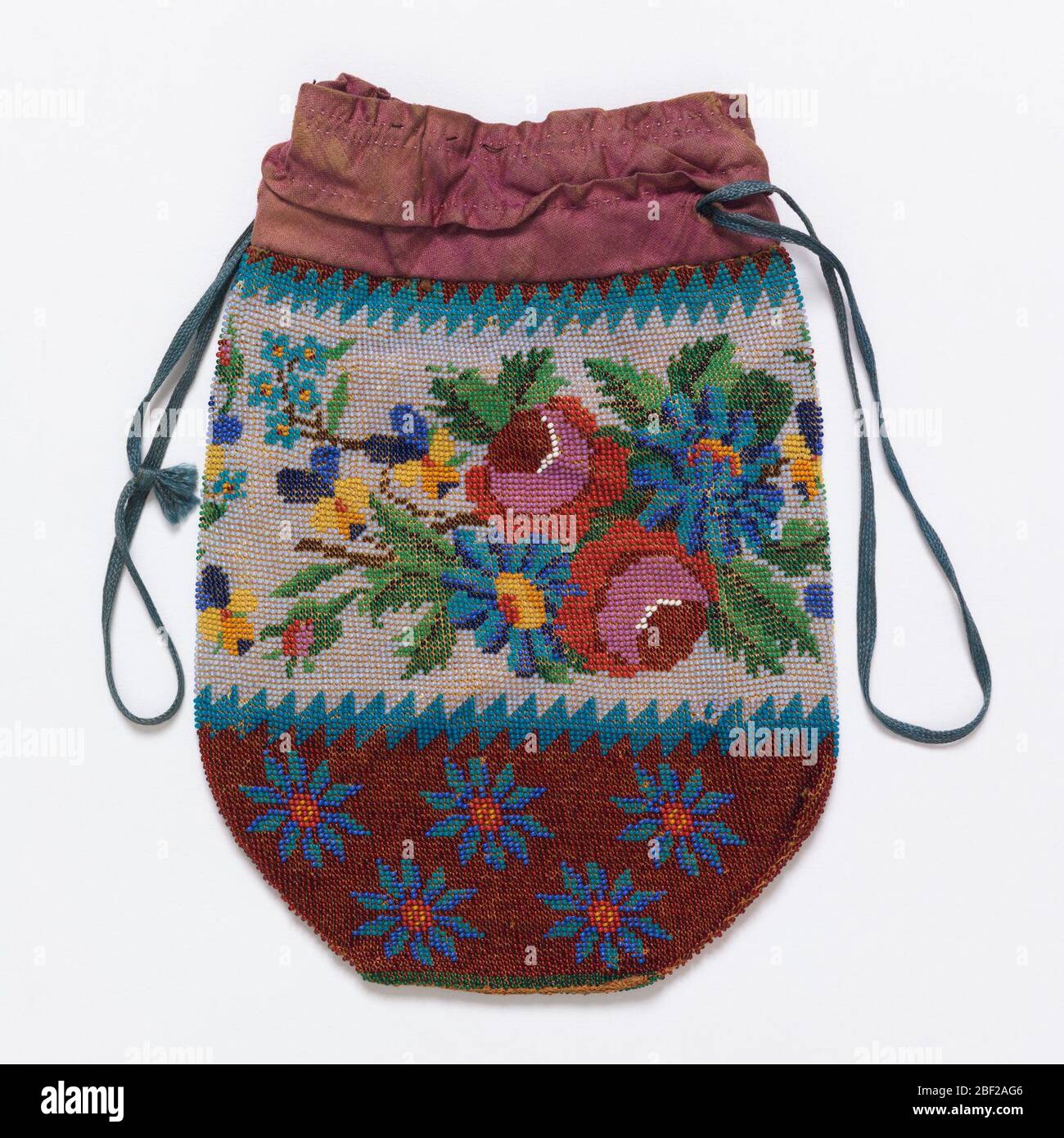 Sacchetto di tabacco. Custodia con coulisse con motivi floreali. La fascia centrale ha fiori blu, rossi e gialli su sfondo bianco. Il fondo della tasca ha fiori blu su una terra rossa scura. Il bordo seghettato separa le fasce. Foto Stock