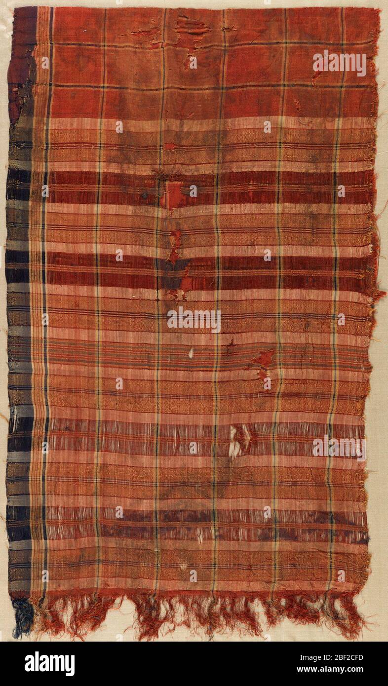 Frammenti. Frammenti di seta tessuta in una tela irregolare di colore rosso con blu scuro, marrone chiaro e crema. Foto Stock