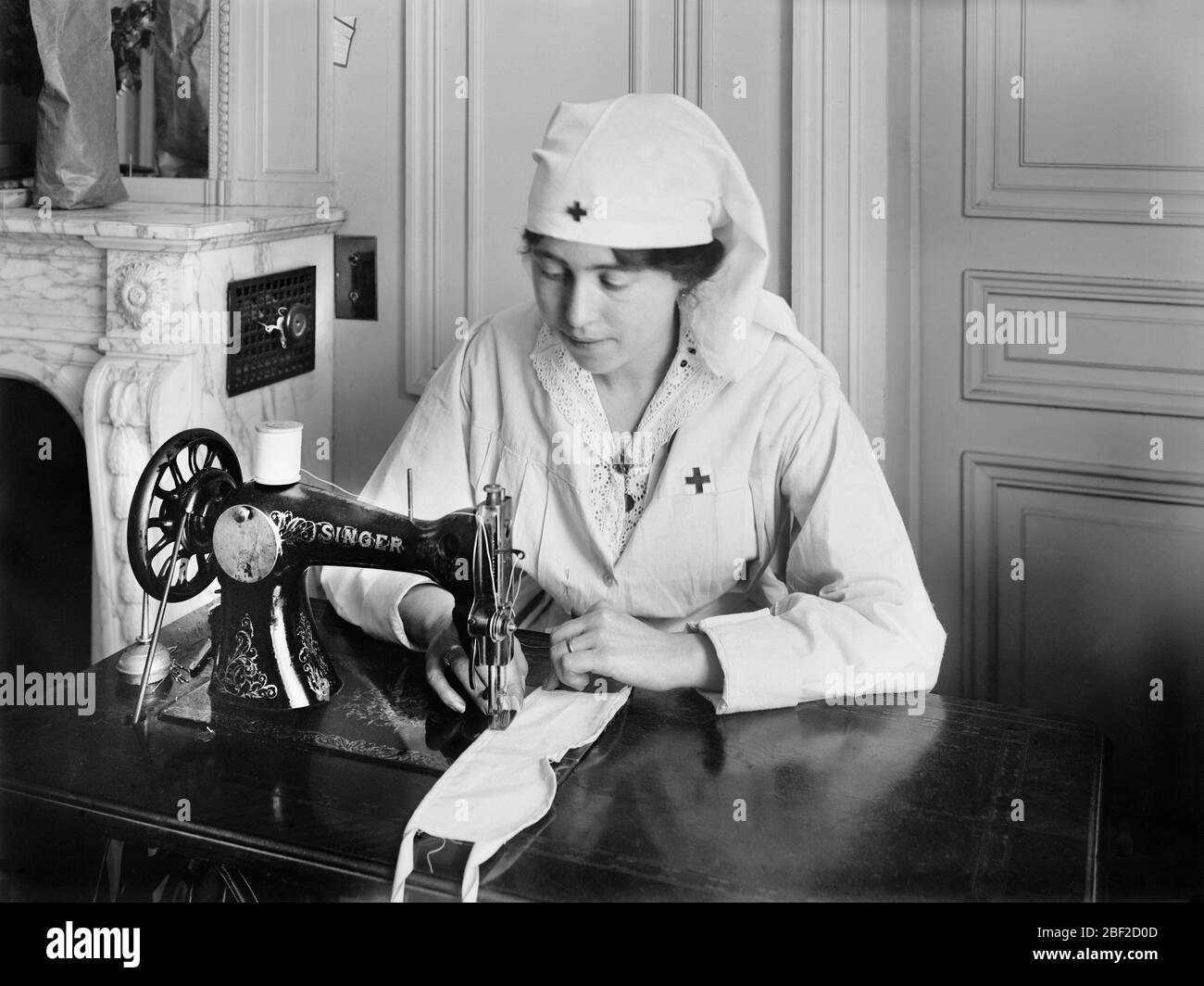 Donna American Red Cross Worker stitching eye bendaggi su Sewing Machine nelle sale di lavoro American Red Cross per Dressings chirurgici, Rue de la Faisandere, Parigi, Francia, Lewis Wickes Hine, American National Red Cross Photograph Collection, luglio 1918 Foto Stock