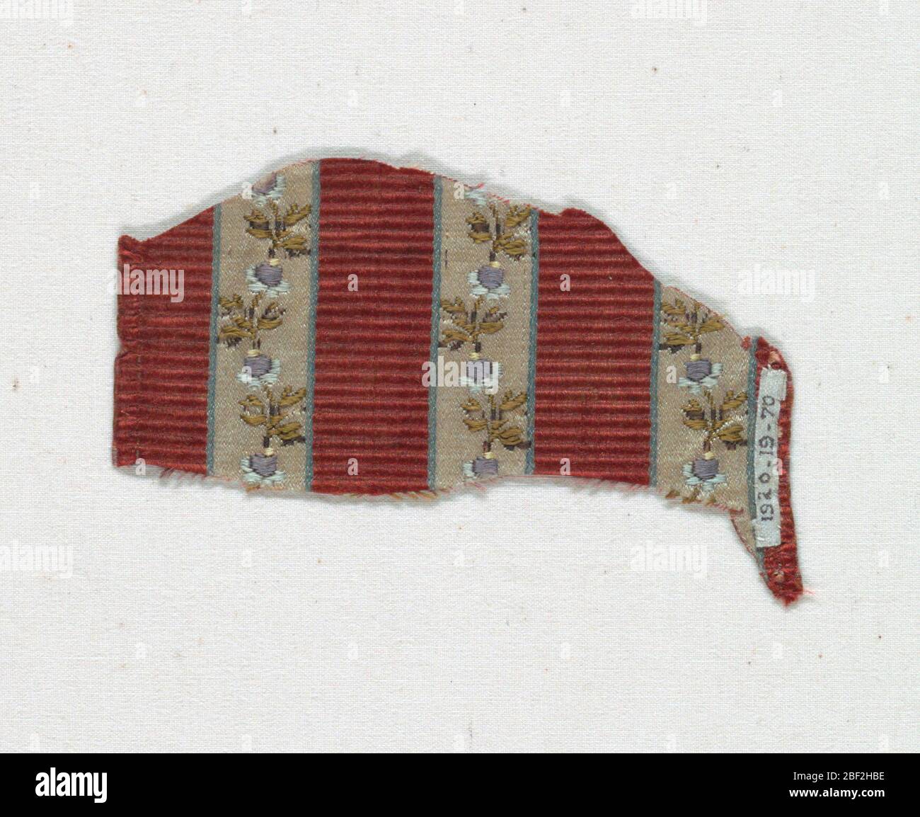 Frammento. Strisce di tessuto a coste di seta rosso scuro alternate a strisce di satin bianco bordate con blu chiaro su cui è puntinato un piccolo motivo floreale. Foto Stock