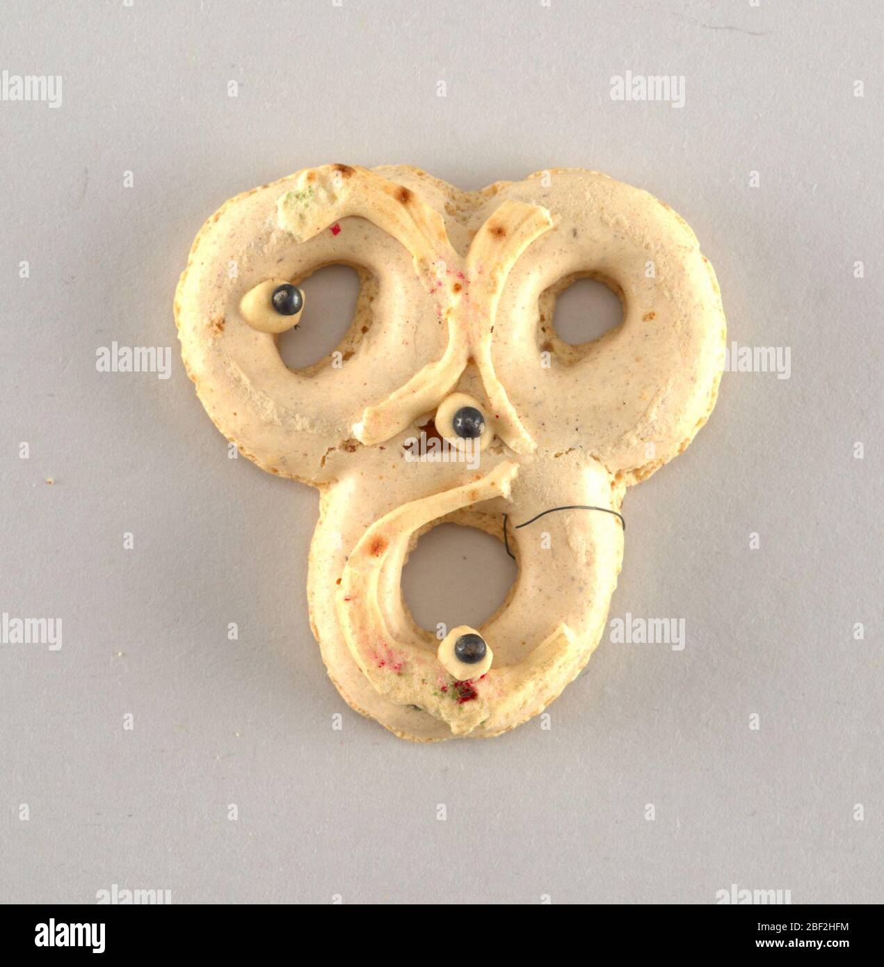 Ornamento albero di Natale. Tre anelli con scaglie di zucchero in rosso e verde e tre perle nere. Foto Stock