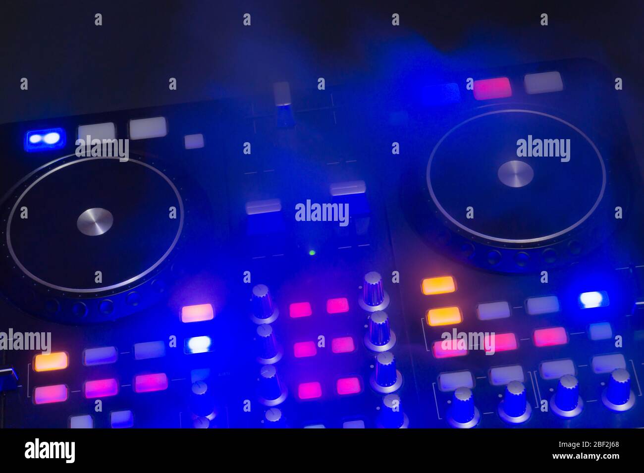 DJ Sound mixer controller con manopole e cursori primo piano. Mixer audio con giradischi al buio con comandi illuminati Foto Stock