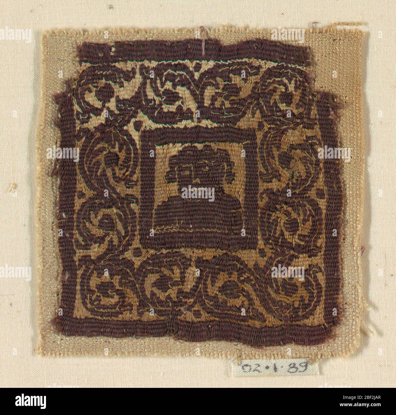 Quadrato. Busto di una figura umana all'interno di un quadrato in un ampio bordo di viti curving. Foto Stock