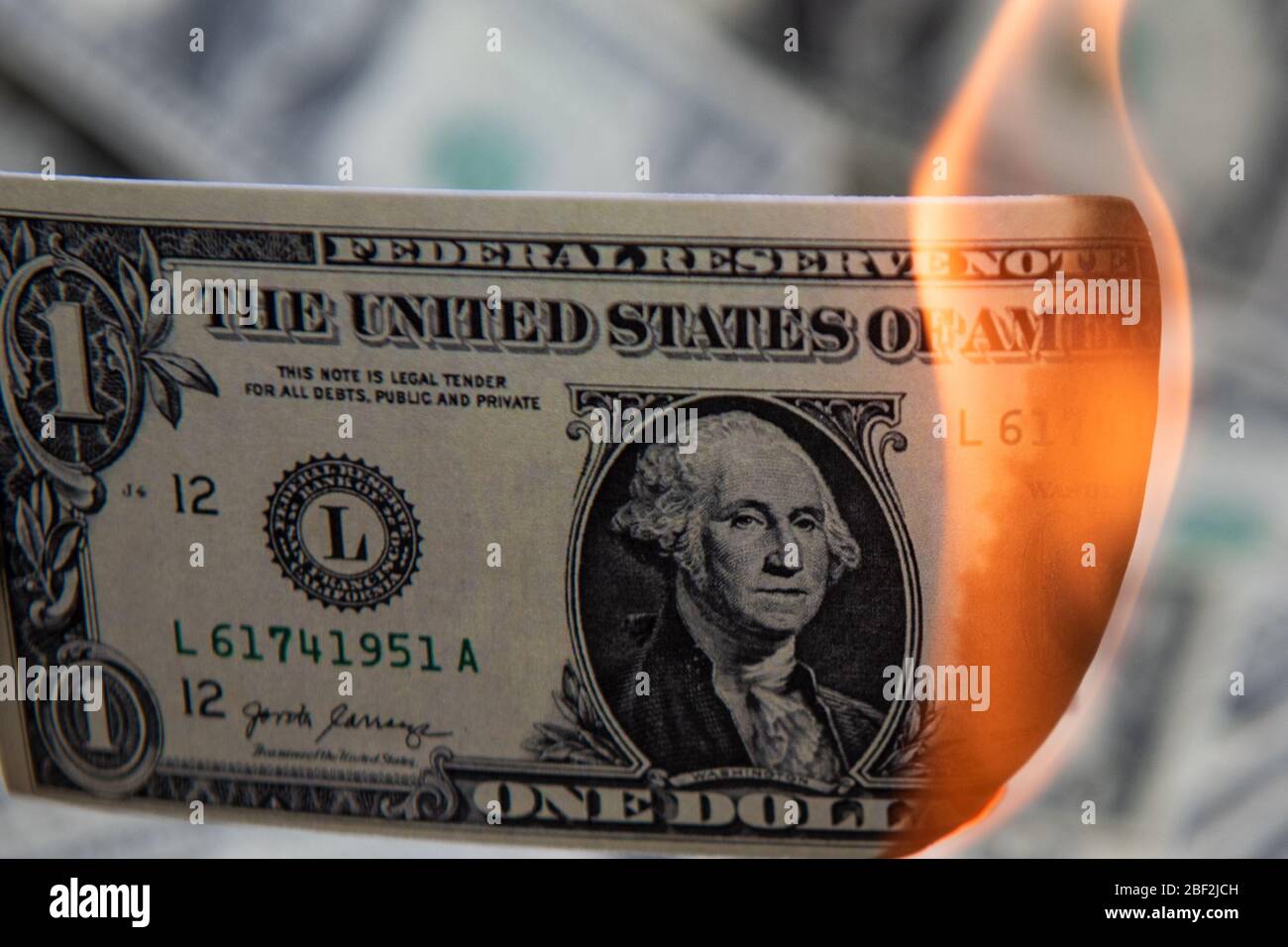 Bruciare cento dollari come simbolo di recessione economica. Foto Stock