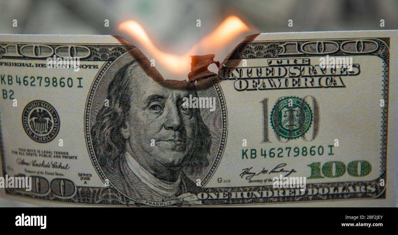 Bruciare cento dollari come simbolo di recessione economica. Foto Stock