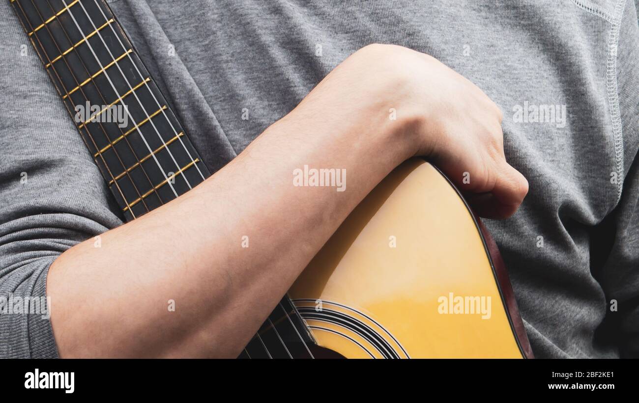 L'uomo tiene la chitarra acustica. Strumento a corda Foto Stock