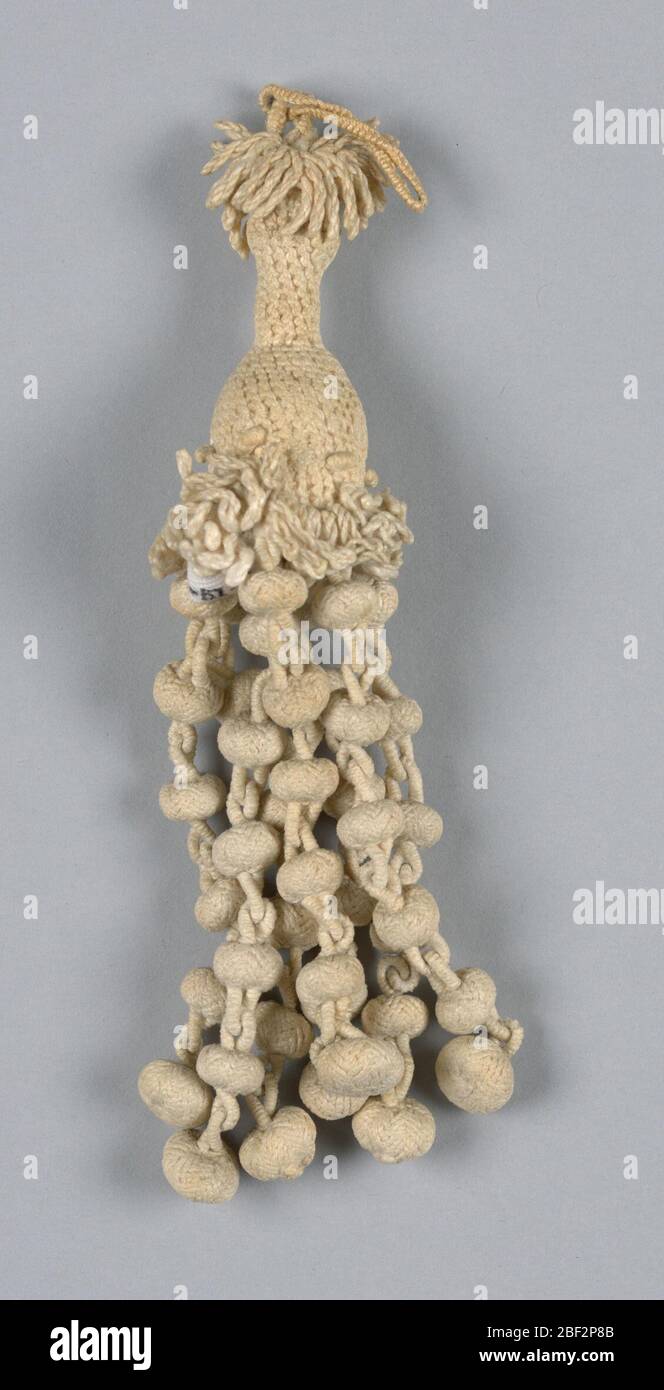 Nappina. Nappina di lino a pera intrecciata e annodata. Anello corto fissato a una unità centrale a pera, da cui pendono sette catene terminali gelate da piccoli elementi circolari e collegate tra loro da anelli. Foto Stock