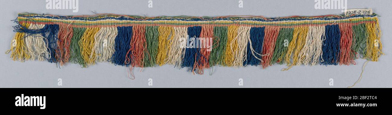 Frangia. Frangia con linea a strisce blu, rossa, verde, gialla e bianca. I fili del mantello, avvolti e ritorti, sono disposti per formare strisce. Foto Stock