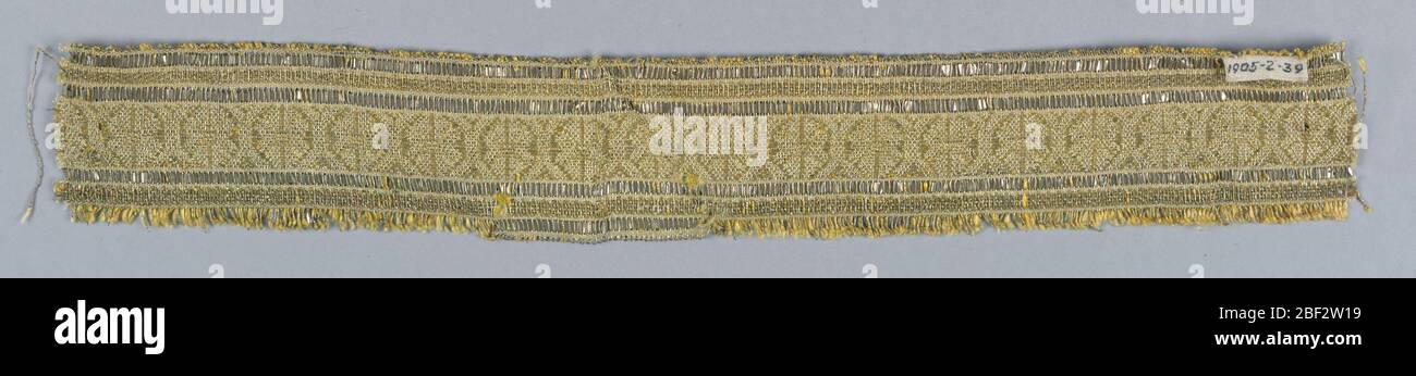 Rifilatura. Disegno di angoli spezzati disposti come una fascia centrale con bordi su entrambi i lati costituiti da strisce metalliche. Fili metallici e strisce su giallo e bianco. Foto Stock