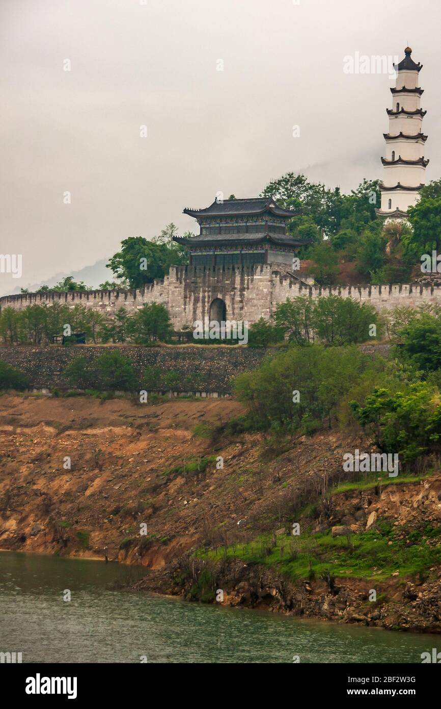 Baidicheng, Cina - 7 maggio 2010: Gola di Qutang sul fiume Yangtze. Porta con torre per sito storico della fortezza su collina con pagoda. Nebbia bianca sulle colline i Foto Stock