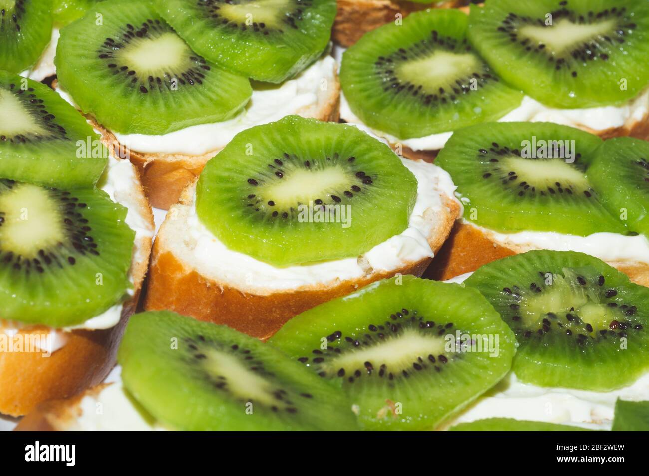 Panini con kiwi, pane con fette di frutta, fondo con antipasto Foto Stock