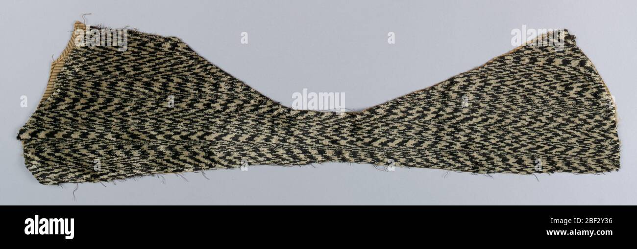 Frammento. Frammento di velluto bianco e nero con motivo a chiazze che suggerisce pelliccia. Taglio a sciarpa e foderato con taffeta a righe nere e tan. Foto Stock