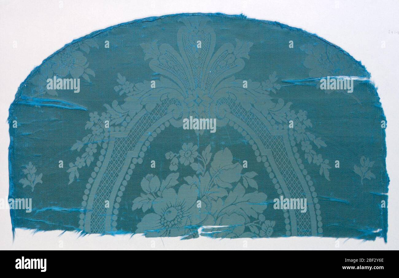 Frammenti. Pannello ovale in damascale blu probabilmente per una sedia schienale con un disegno di una cornice ovale che racchiude un gruppo floreale. Acanthus lascia e oscilica sotto la cornice. Foto Stock