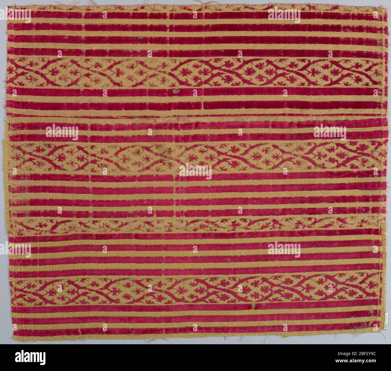 Frammento. Bande di velluto rosso su sfondo giallo. Foto Stock