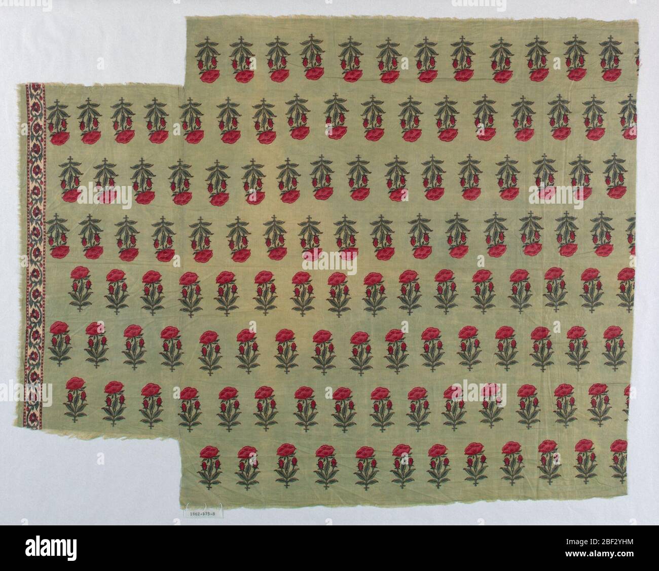 Tessile. Frammento in rosso e verde su terra verde chiaro. Stilizzato, allover motivo floreale di una pianta di semi di papavero. Una striscia di bordo presente che mostra un disegno floreale su piccola scala su sfondo bianco. Foto Stock