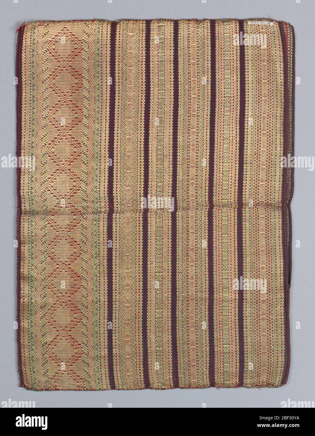 Tessile. Due pezzi cuciti insieme, possibilmente per l'uso come borsa o custodia. Terra di seta viola a righe orizzontali in viola, rosso e verde. Il filo metallico in oro crea figure geometriche in trama extra su queste strisce. Foto Stock