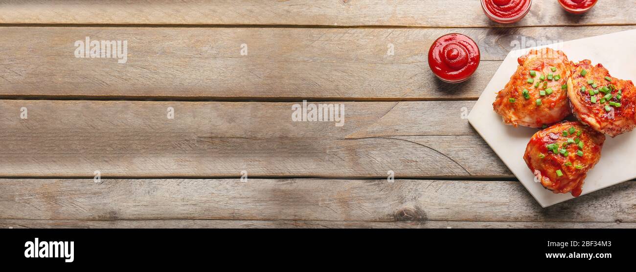 Cosce di pollo cotte con salsa di pomodoro sul tavolo con spazio per il testo Foto Stock