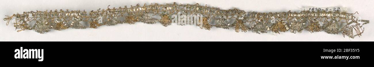 Rifilatura. Rifilatura con un bordo diritto e un bordo smerlato formato da pezzi a ventaglio, alternativamente argento e oro. Foto Stock