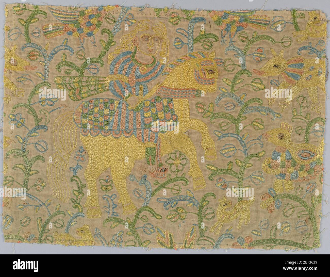 Frammenti. Frammenti di seta ricamata su lino in stile Mughal. Il design mostra l'uomo con pugnale a cavallo circondato da piante e animali. Foto Stock
