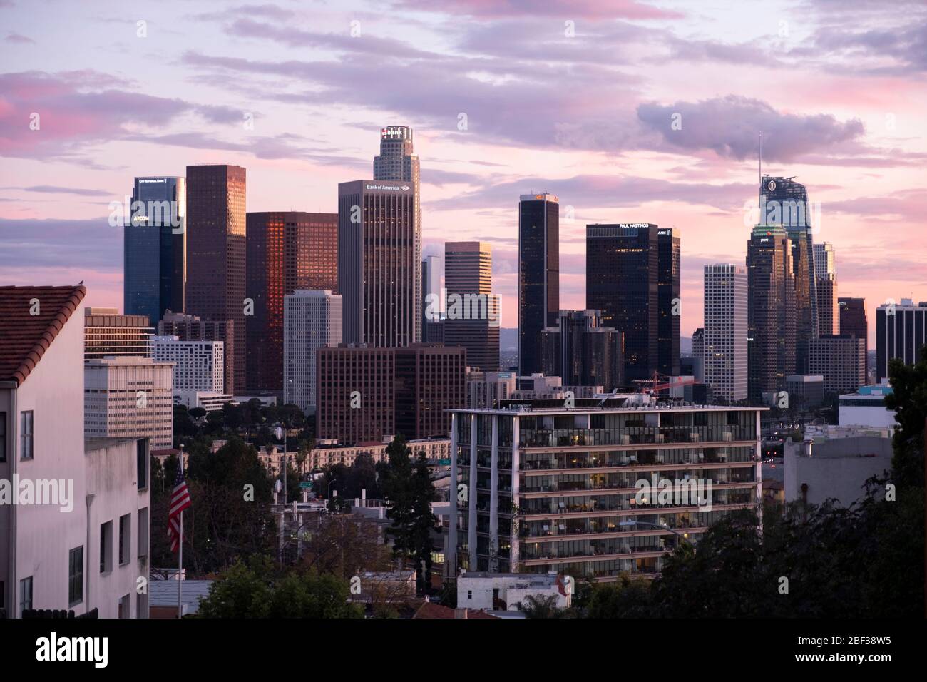 Skyline di Los Angeles al tramonto con nuvole rosa e dorate colorate nel cielo, visto dal quartiere di Angelino Heights Foto Stock