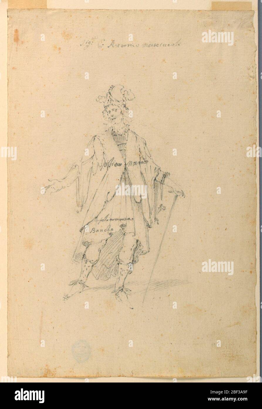 Costume Design un uomo in abbigliamento fantastico per un balletto. Rettangolo verticale. Un uomo è mostrato dalla parte anteriore. Indossa un cofano con piume, un cappotto di pelle e una gonna. La sua mano sinistra si appoggia su un bastone. Scritto attraverso il petto è 'folia morta' le stesse parole sono state colpite fuori nella gonna. Foto Stock