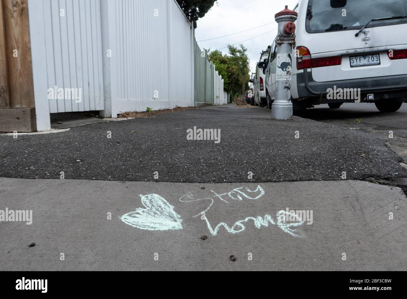 Covid-19, Coronavirus, crisi pandemica a Melbourne Australia 2020. Messaggio di gesso di soggiorno a casa scritto su un sentiero in una via Melbourne. Foto Stock