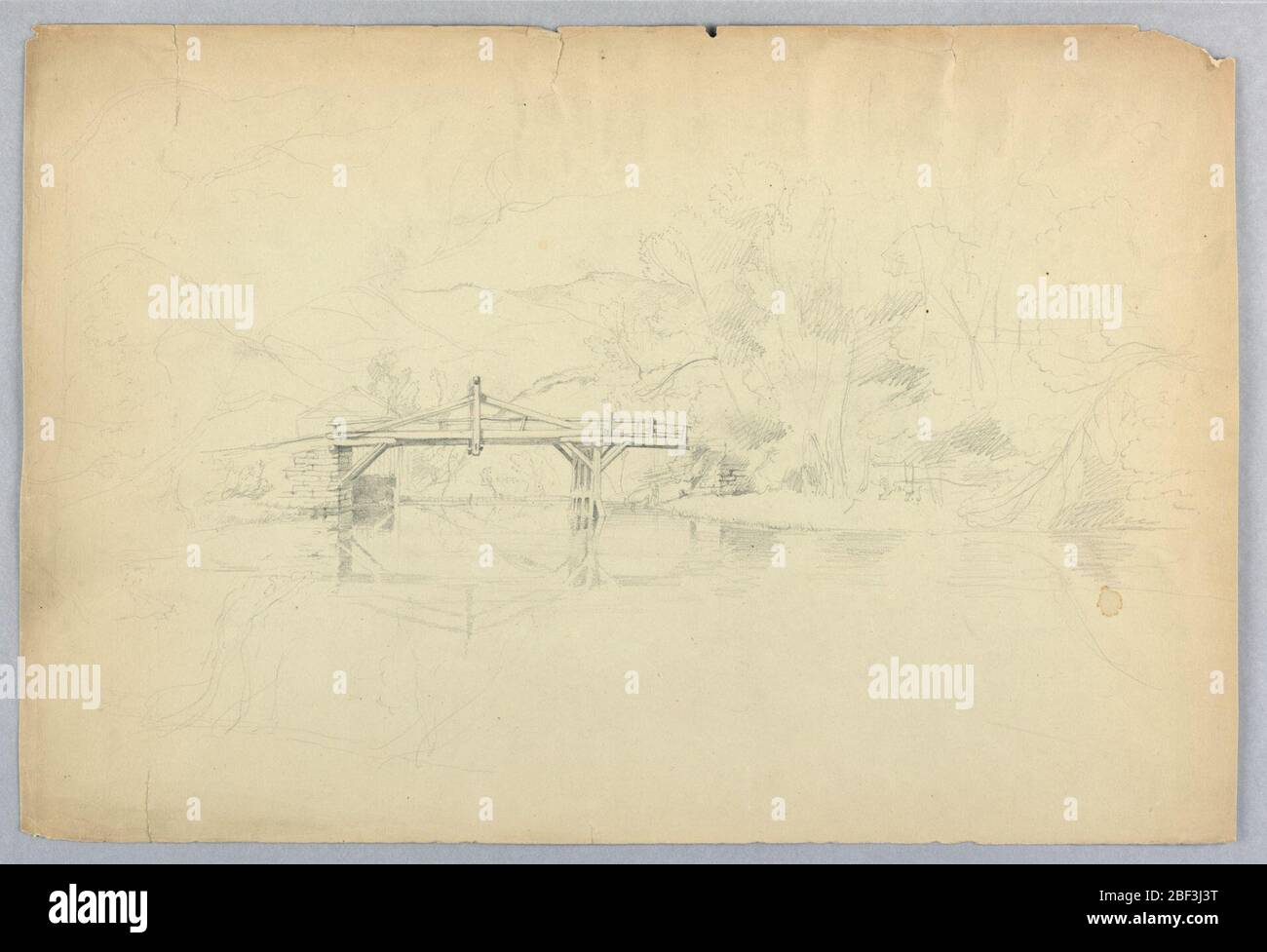 Ponte su un piccolo fiume. Ponte, a sinistra centro, con montagne oltre. Banche, sinistra e destra; alberi grandi, destra. Foto Stock