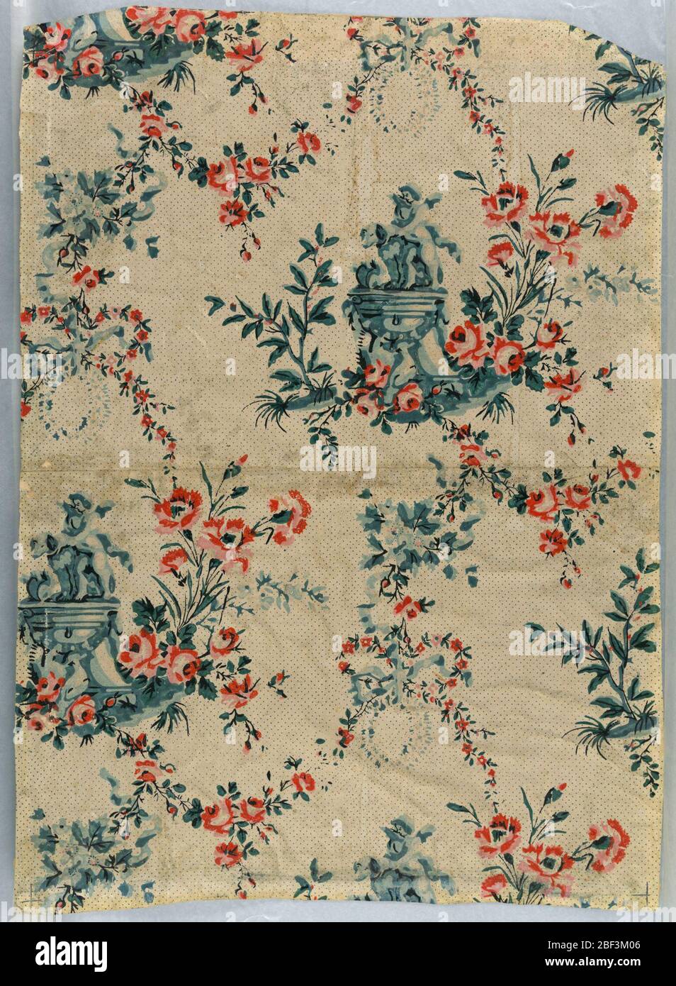 Parete laterale. Disegno ripetuto di putto e cane su piedistallo collegato da swag floreali in disposizione casuale, con dritto attraverso corrispondenza. Gruppo piedistallo, grigio-blu. Rose e garofani, arancio rosato. Puntino su fondo, blu scuro su crema. Foto Stock
