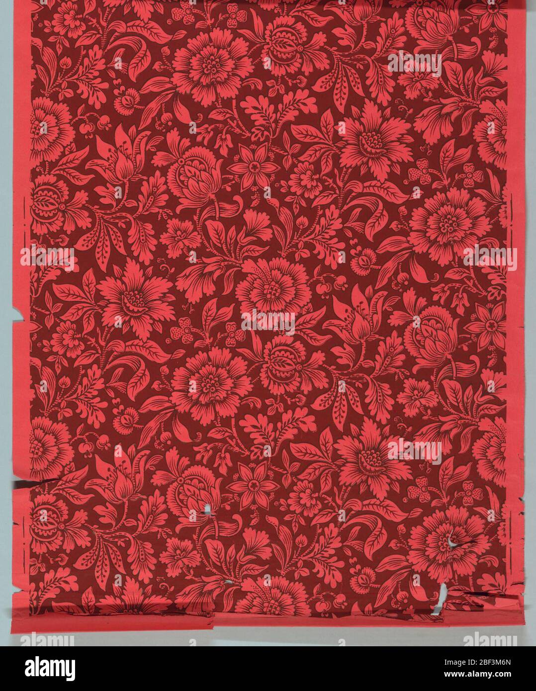 Parete laterale. Tuta floreale stilizzata di tipo chintz. Stampato in due colori. Lo sfondo è stampato in rosso intenso con il motivo floreale che è la carta instampata in rosso. Ogni motivo è delineato con una linea nera fine. Foto Stock