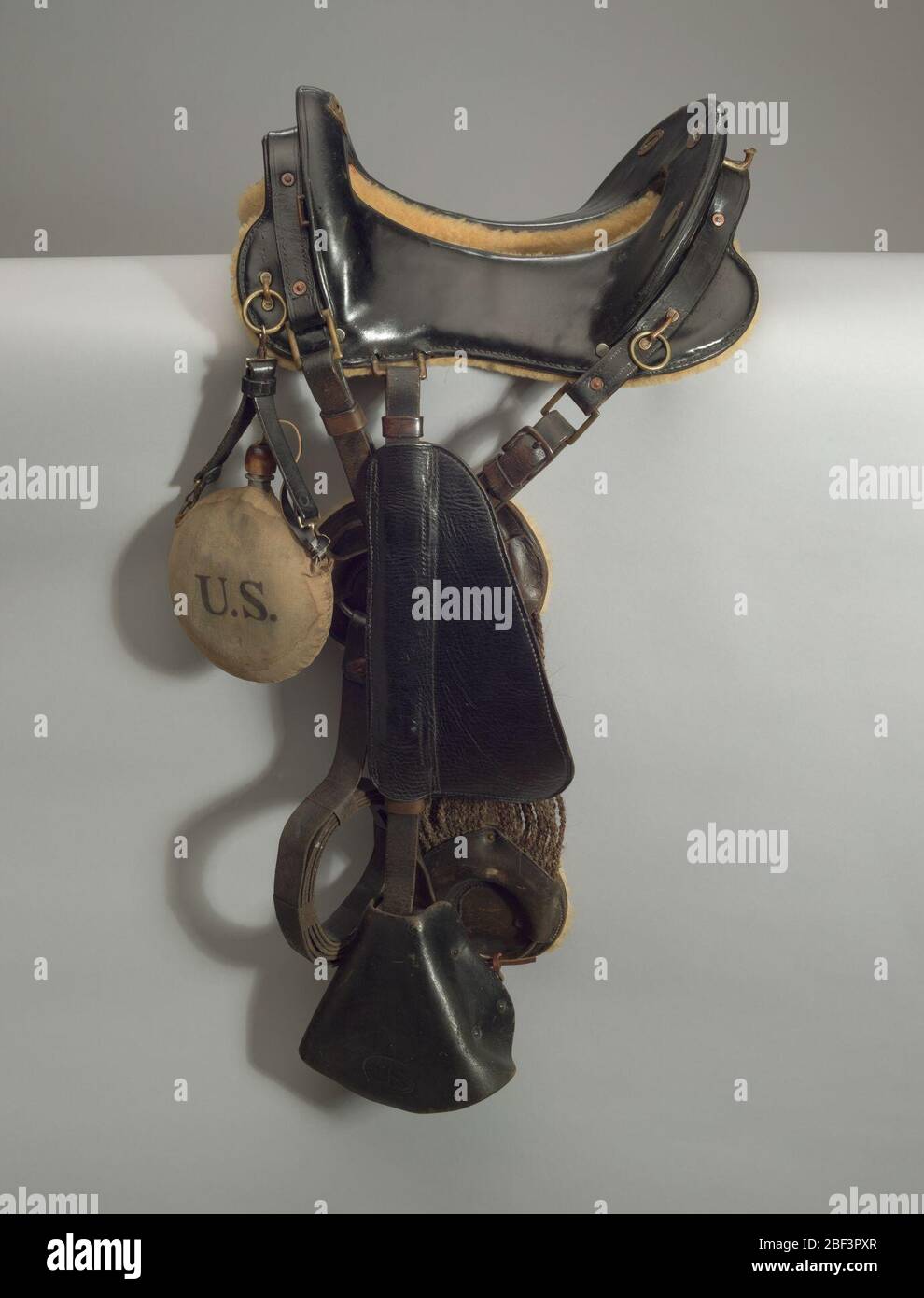 Sella a cavallo utilizzata dallo stuntman Ernest Ernie Robinson. Una sella a cavallo utilizzata da Ernest Robinson. Presenta due staffe rivolte verso la parte anteriore. Ogni staffa è rivestita in pelle dove poggia il piede. Ogni lato è dotato di un parafango in pelle che copre la parte con cintura della staffa e della cinghia per hobble. Foto Stock