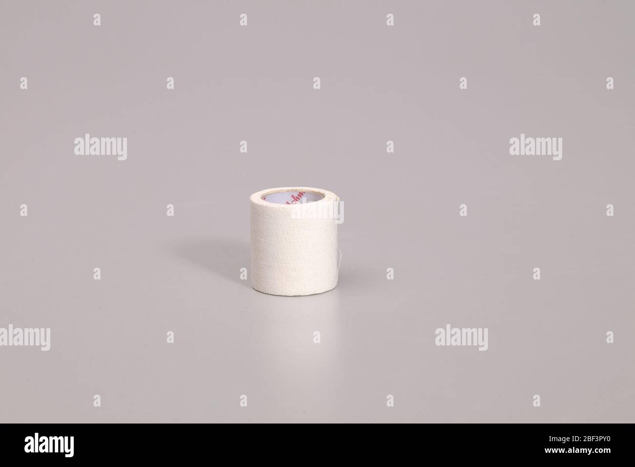 Nastro medico utilizzato da Gabby Douglas durante le Olimpiadi del 2012. Un rotolo di nastro medicale bianco. Il tubo del carboard al centro è bianco con il logo Johnson & Johnson ripetuto in rosso. Foto Stock