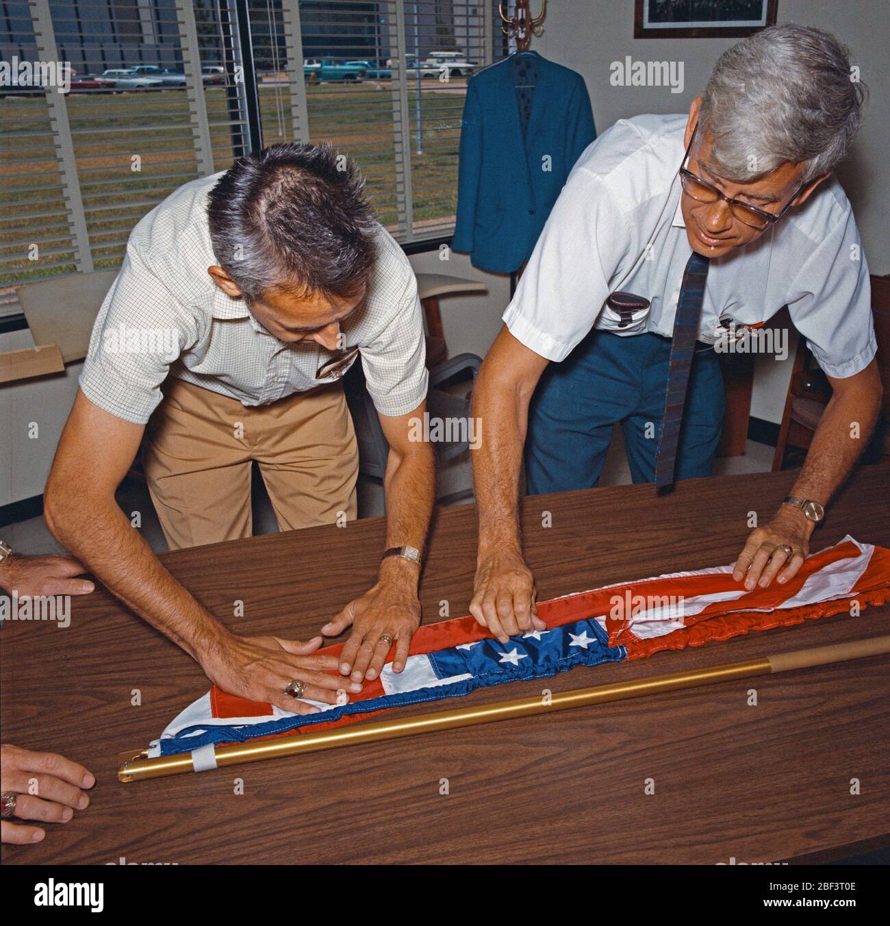 (1969) -- Jack Kinzler, a destra con la bandiera americana kit per Apollo 11, visto in servizi tecnici shop in costruzione 9. Foto Stock