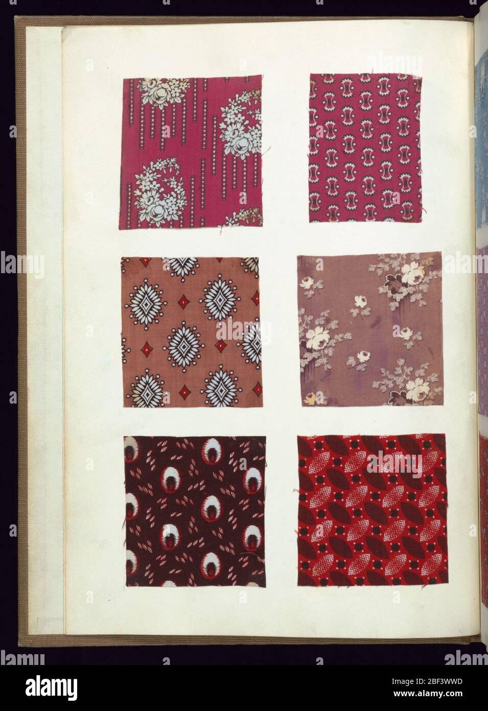 Libro di esempio. Libro campione con copertina stampata in marmo e striscia posteriore in pelle scamosciata verde contenente campioni di tessuti stampati in cotone in vari colori che vengono incollati su fogli di carta. Foto Stock