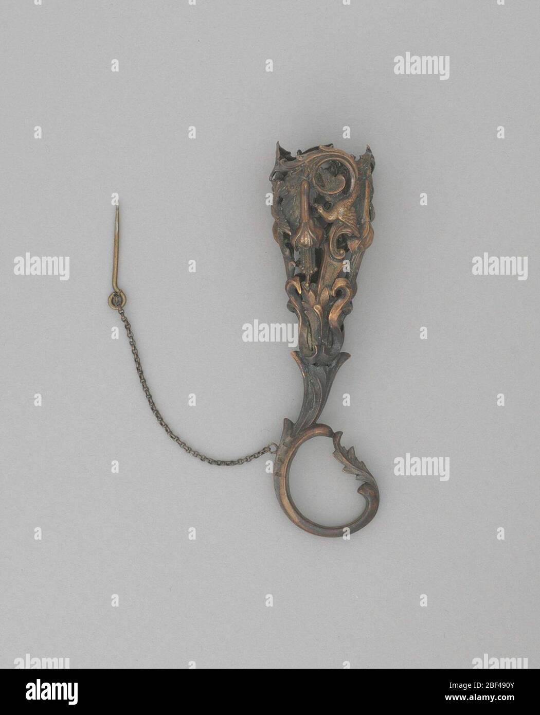 Mazzo porta uccelli e foglie motivo. Supporto per bouquet in rame con manico ad anello. Il vaso del portadouquet è stato stampato con quattro ripetizioni di un disegno che presenta uccelli, foglie e fiori sopra un modello ripetitivo di forme ‘S. Tra uno degli uccelli e un bocciolo appeso è un foro per un pin floreale. Foto Stock
