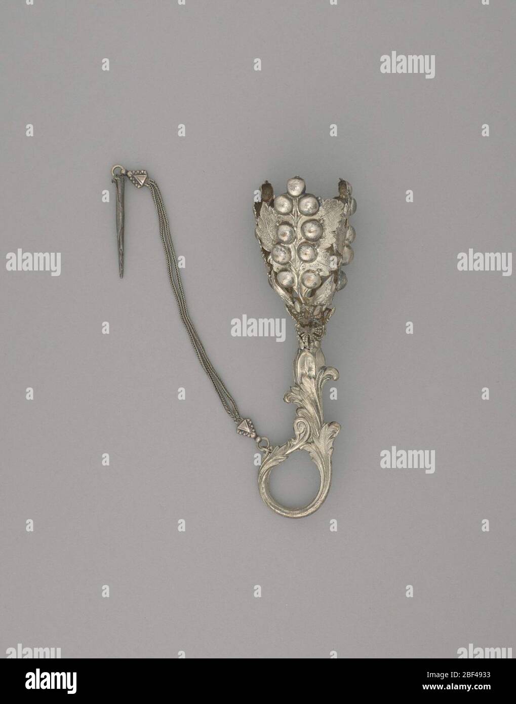 Porta bouquet foglie e bacche a doppia catena. Supporto per bouquet in argento con manico ad anello. Il vaso del portatore è formato da quattro foglie ricoperte da grandi bacche sul ramo. Vicino alla parte superiore del supporto c'è un foro per il pin floreale. Foto Stock