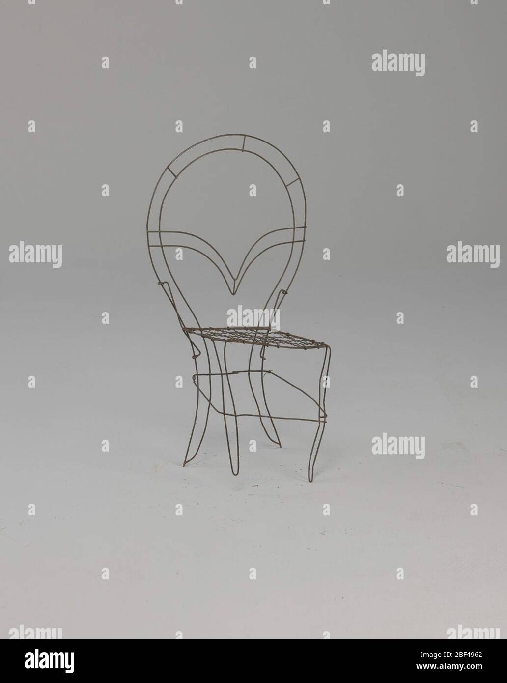 Sedia con struttura in filo in miniatura. Alcuni dei disegni più popolari nei fiori funerali nel tardo diciannovesimo secolo erano quelli che hanno attratto al sentimentalismo del periodo. Questi disegni della cornice del fiore erano sia decorativi che più personali nei loro riferimenti. Foto Stock