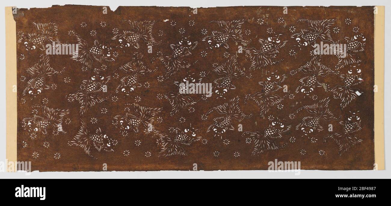 Pesce d'oro. Sparsi intorno allo stencil sono pesci d'oro molto piccoli. I metodi di punzonatura e di intaglio sono stati applicati per creare l'immagine whimsical. Dispersi in tutto il disegno sono piccoli fiori floreali che imitano i dettagli del pesce. Foto Stock