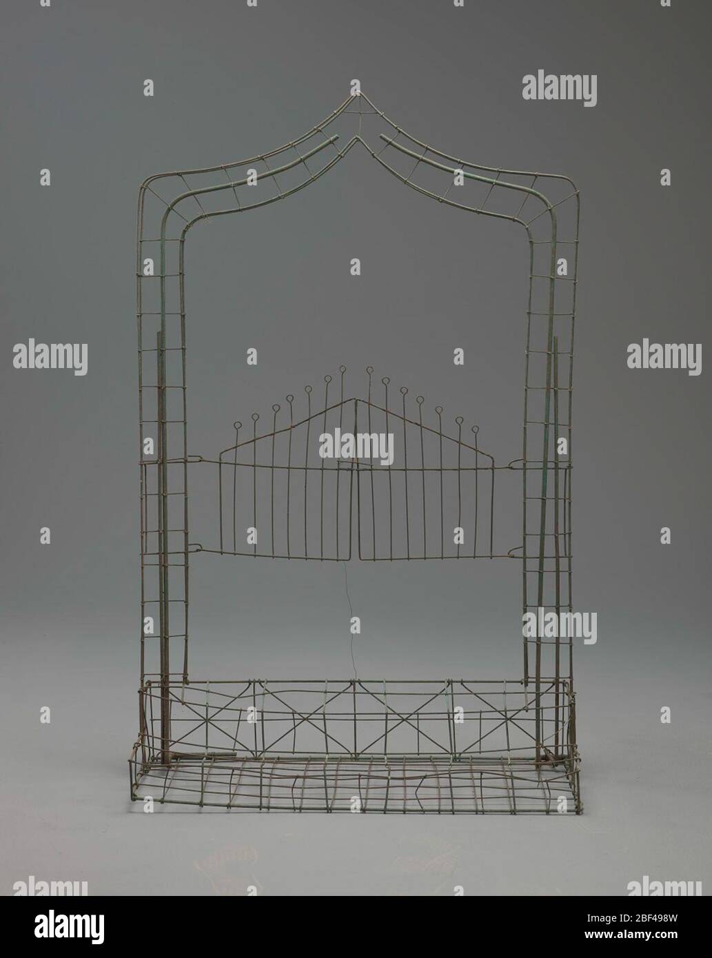 Cancelli con telaio a filo socchiusi grandi. Il set Gates Ajar o Gates of Heaven era un design particolarmente elaborato e molto popolare tra la fine del XIX secolo e l'inizio del XX secolo. Generalmente andava da due a quattro piedi di altezza con archi appuntiti o arrotondati su un paio di porte. Foto Stock