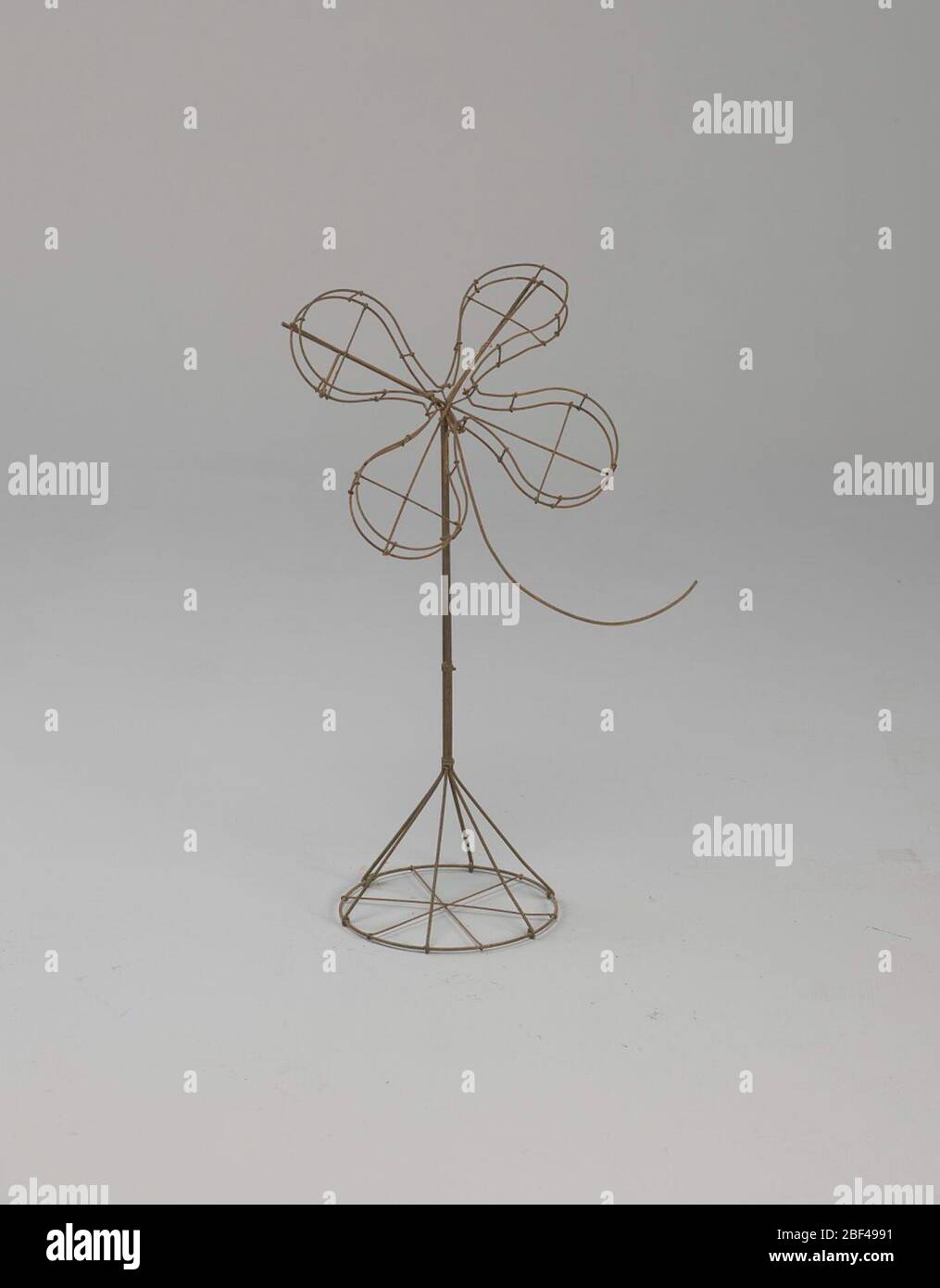 Telaio in filo quattro foglie di trifoglio su supporto. La cornice del fiore del trifoglio potrebbe essere usata per una varietà di scopi. Simboli di buona fortuna, come il ferro di cavallo, il trifoglio a quattro foglie, corna di abbondanza e le ossa-desideri sono apparse in eventi come aperture del negozio, graduazioni e altre celebrazioni. Foto Stock