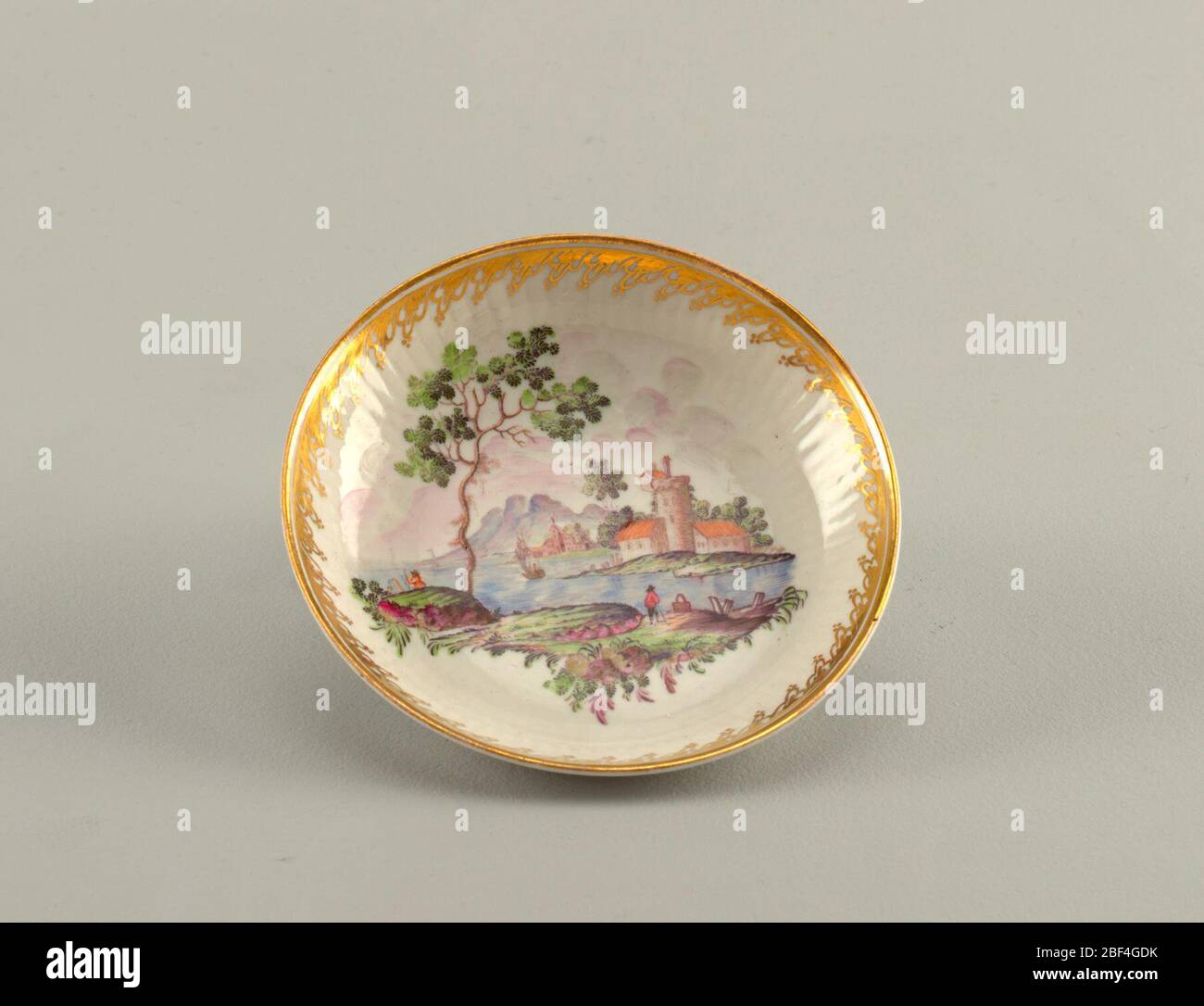 Tazza e piattino. Tazza semplice, manico semplice; piattino poco profondo con lato leggermente curvo, rigato in rilievo underglapy. Paesaggi su tazza e piattino; lacy bordo oro su piattino. Foto Stock