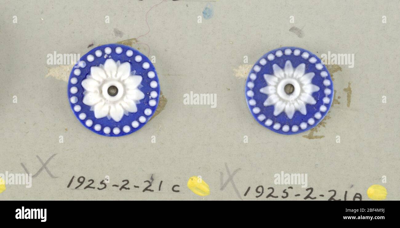 Pulsante. Tre medaglioni circolari in stile wedgewood Jasperware; fiore aperto con dodici petali circondati da un anello di puntini; bianco su terra blu; foro centrale.su carta 4 Foto Stock
