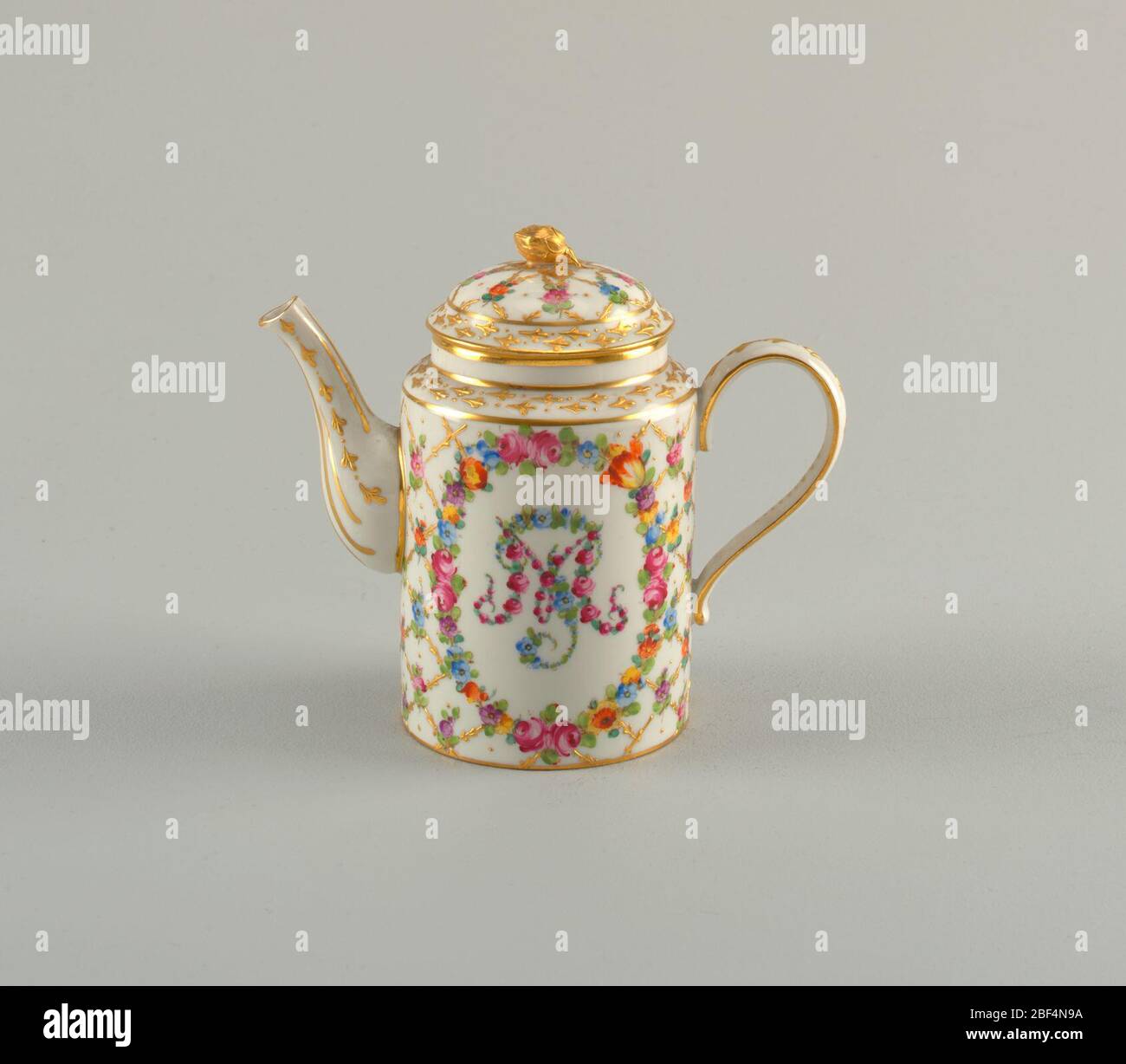 Caffettiera con monogramma e motivo a reticolo diamantato. Corpo cilindrico e coperchio a cupola con finiale floreale dorato. Disegno pannolino con fiori ai passaggi. Beccuccio e manico dorati. Monogramma floreale. Foto Stock