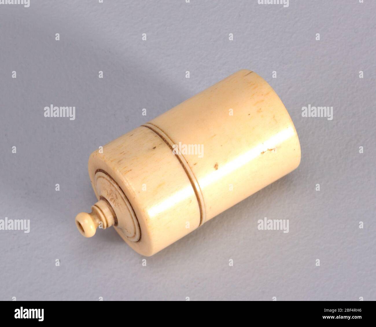 Attacco a presa e vite. Tornito, legno scuro, in forma colonnare, con la parte superiore che arriva ad un punto, terminante con piccolo, sporgente, avorio che tiene il fiammifero; la parte superiore girata della scatola si svita per rivelare il contenitore del fiammifero; piccolo tondo di carta vetrata aderito al fondo per il percussore. Foto Stock