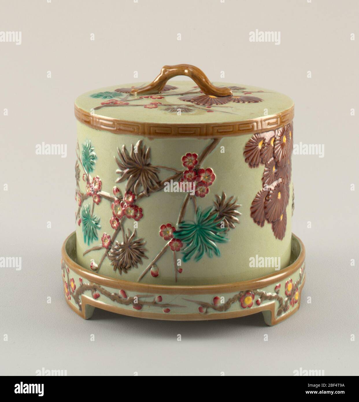 Piatto e coperchio. A) campana cilindrica cava, dritta, con sommità piatta. Modellato con rami di fioritura asimmetrici in marrone con fiori rossi, foglie verdi e marroni e con grappoli di crisantemi. La parte superiore della campana contiene ornamenti simili, con impugnatura a spirale applicata. Foto Stock